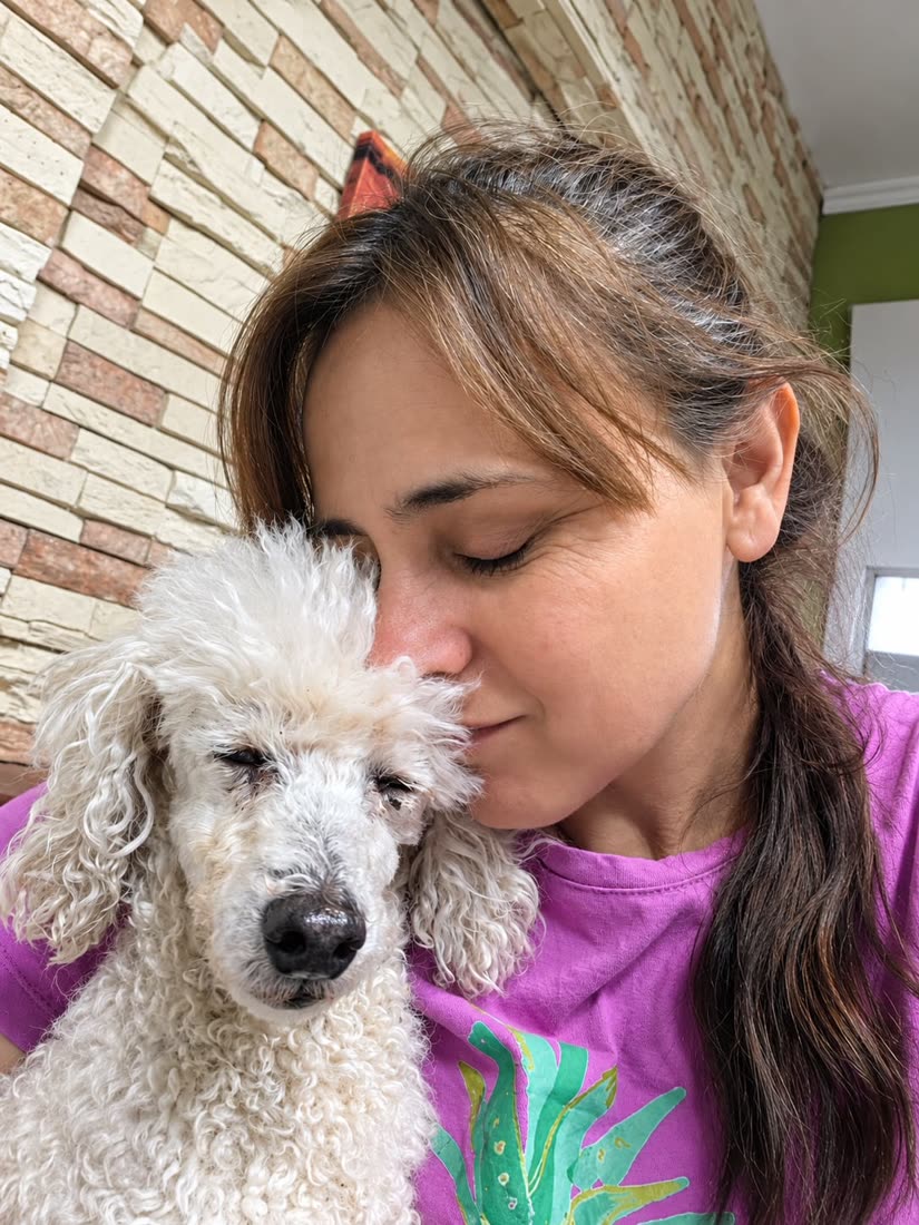 Abrazo con un caniche blanco en Guardería Canina Sandru, Funes